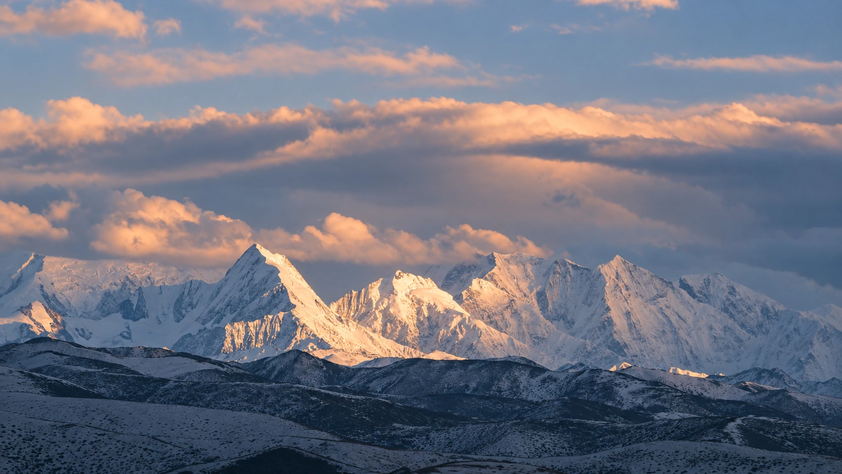 日照金山：暖色阳光照亮雪峰与云层